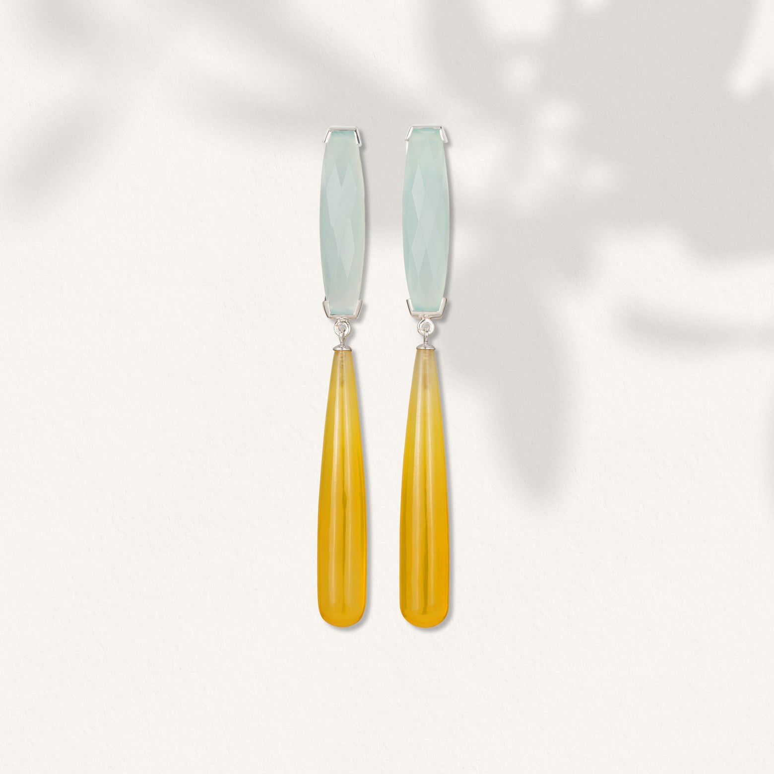 kelly Woodcroft handmade silver earrings featuring two elongated chalcedony teardrops in ice blue and yellow.