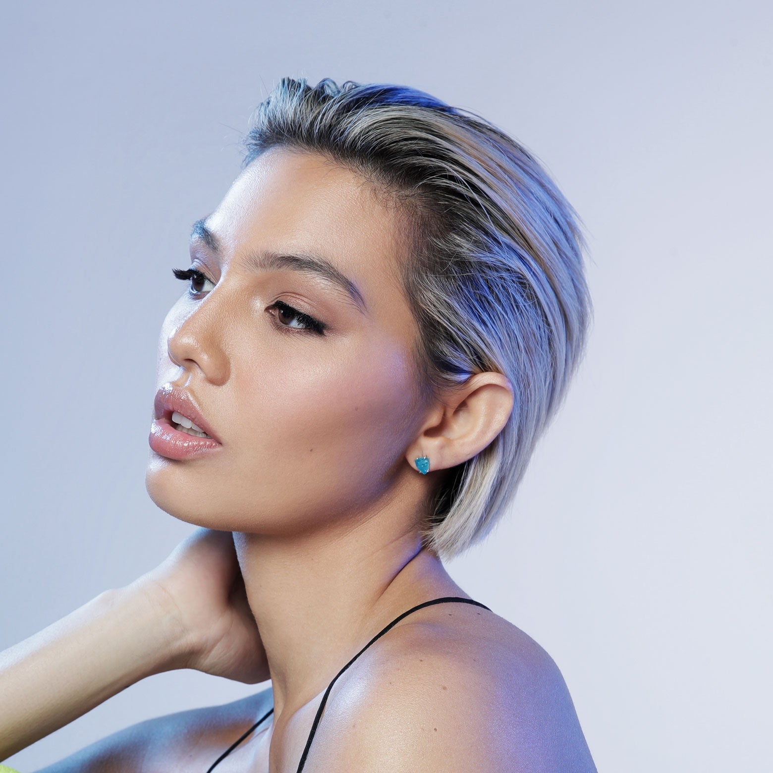 Woman wears neon blue apatite stud earrings